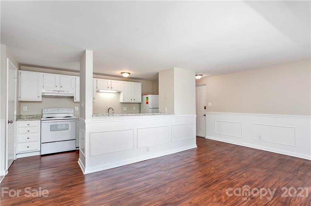 9405 Old Concord Road, Unit J Charlotte, NC 28213 - Photo 1 of 15 a view of a kitchen with white cabinets and wooden floor