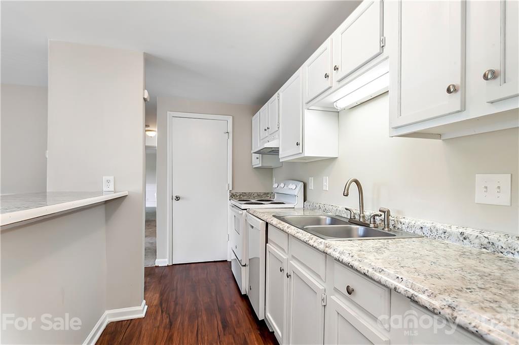 9405 Old Concord Road, Unit J Charlotte, NC 28213 - Photo 3 of 15 a kitchen with granite countertop a sink a stove and cabinets