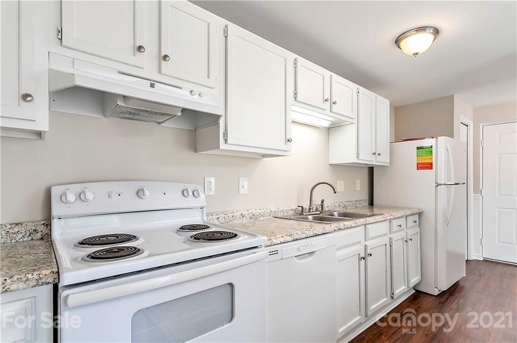 9405 Old Concord Road, Unit J Charlotte, NC 28213 - Photo 4 of 15 a kitchen with stainless steel appliances granite countertop a sink a stove and white cabinets