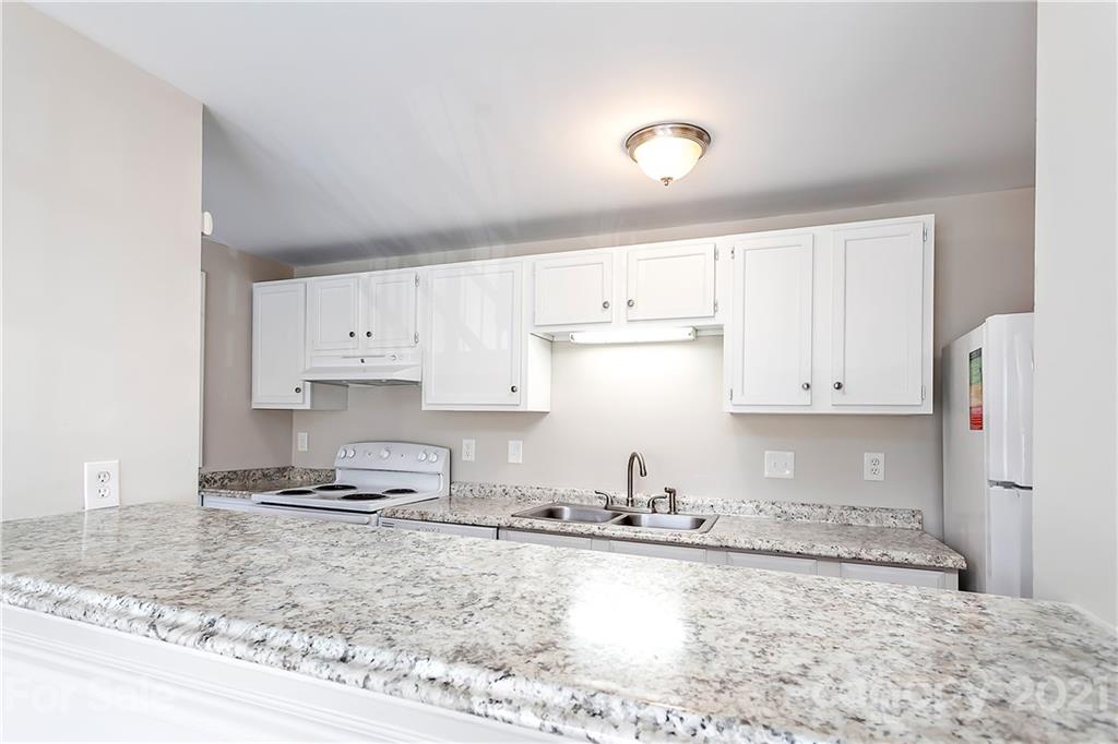 9405 Old Concord Road, Unit J Charlotte, NC 28213 - Photo 5 of 15 a kitchen with granite countertop a sink a stove and cabinets