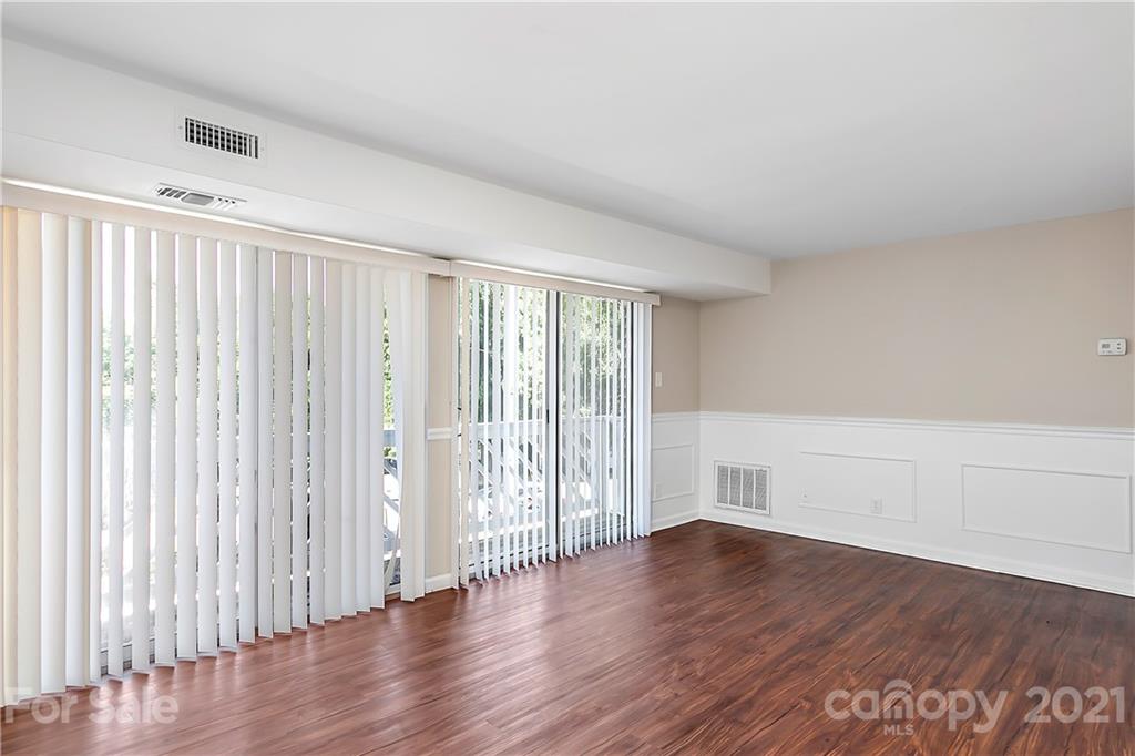 9405 Old Concord Road, Unit J Charlotte, NC 28213 - Photo 6 of 15 an empty room with wooden floor and windows