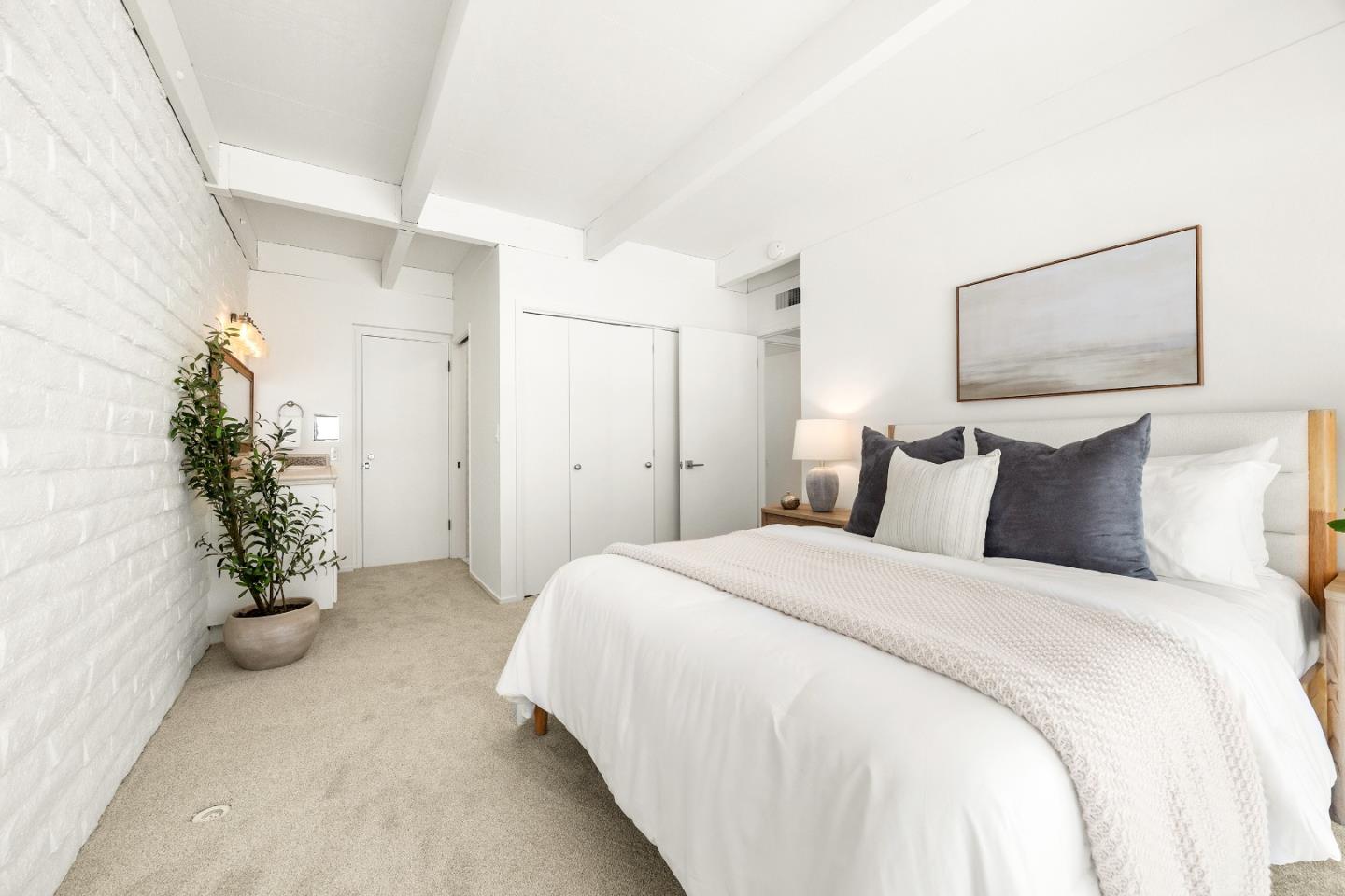 230 Rio Del Mar Boulevard, Unit K Aptos, CA 95003 - Photo 15 of 29 a spacious bedroom with a bed and a potted plant