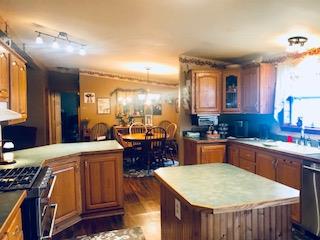 60 Mill Street Rimersburg, PA 16248 - Photo 7 of 17 a kitchen with kitchen island granite countertop wooden cabinets a sink a stove and a refrigerator