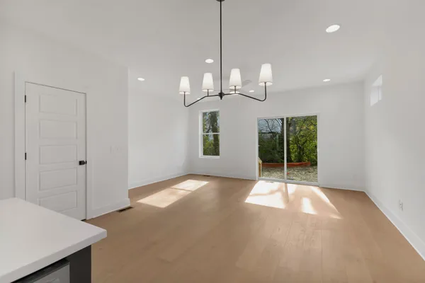 a view of a room with wooden floor potted plant and windows