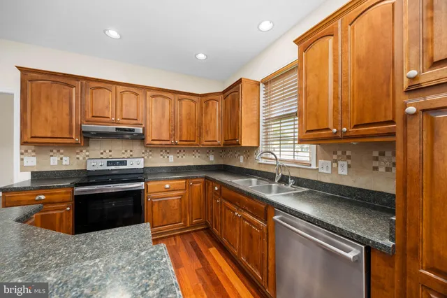 a kitchen with stainless steel appliances granite countertop a stove and a refrigerator