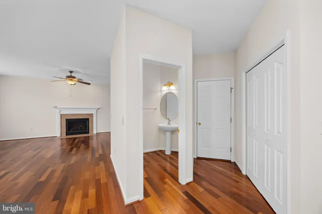 a view of kitchen and empty room with wooden floor