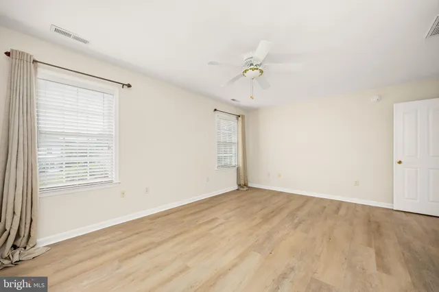 an empty room with a ceiling fan and a window