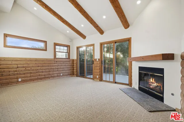 a view of an empty room with a fireplace and a window