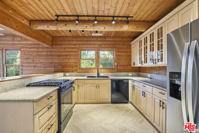 a kitchen with stainless steel appliances granite countertop a sink and wooden cabinets