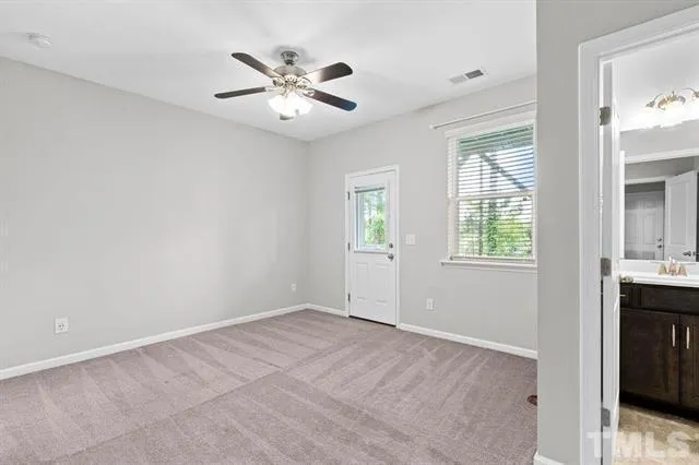 an empty room with windows and fan