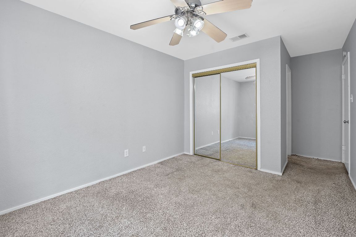 2104 Cullen Avenue, Unit 4224 Austin, TX 78757 - Photo 15 of 24 an empty room with closet and a chandelier fan