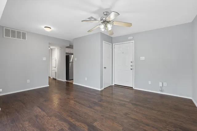 a view of an empty room with wooden floor