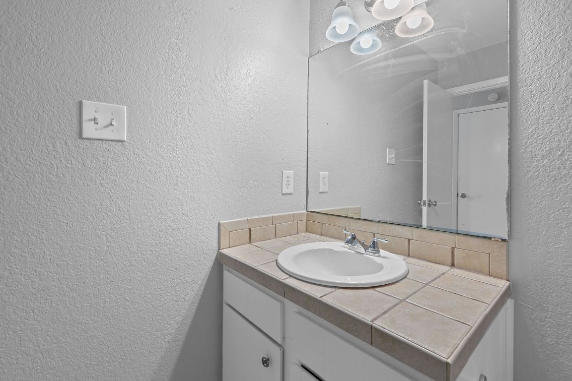 2104 Cullen Avenue, Unit 4224 Austin, TX 78757 - Photo 22 of 24 a sink and a mirror