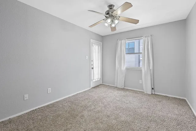 a view of an empty room with a chandelier fan