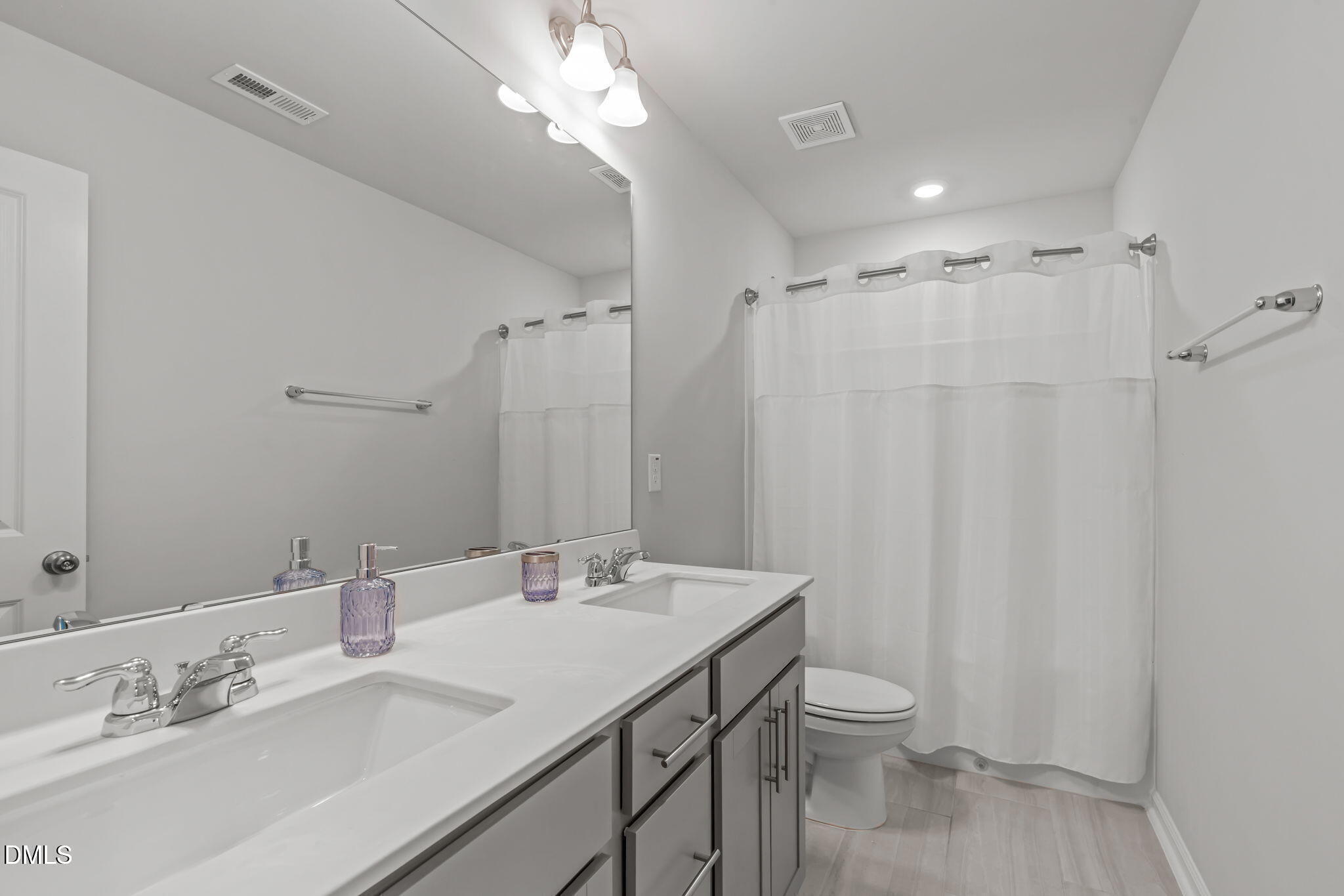 1809 Barrett Run Trail Apex, NC 27502 - Photo 18 of 23 a bathroom with a double vanity sink toilet and a mirror