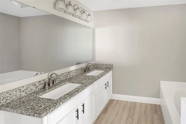 a bathroom with a granite countertop sink and a mirror