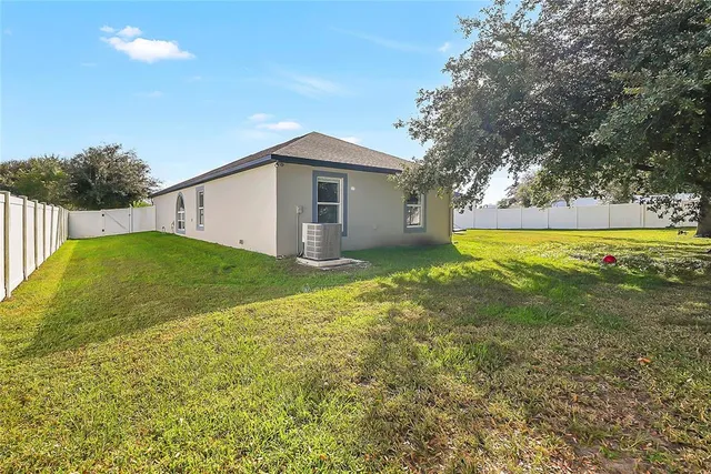 a view of a house with a backyard and a tree