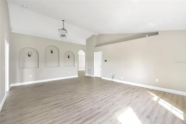 a view of empty room with wooden floor