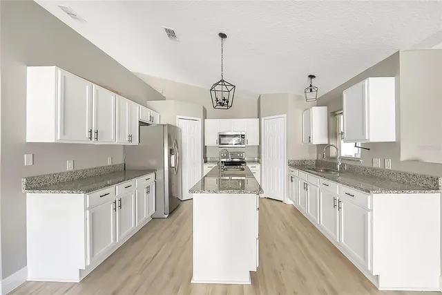 an open kitchen with granite countertop a stove oven and a sink