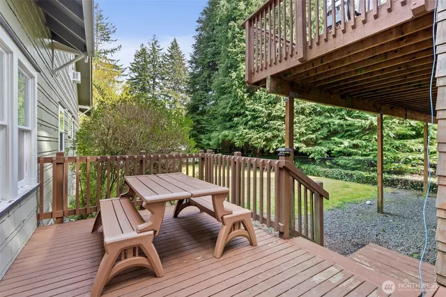 a backyard of a house with barbeque oven and trees
