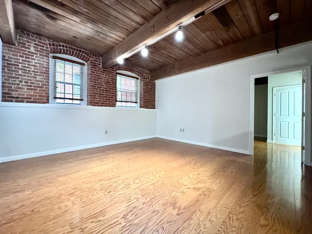 a view of empty room with wooden floor