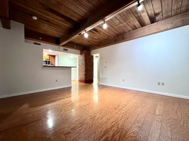 a view of empty room with wooden floor