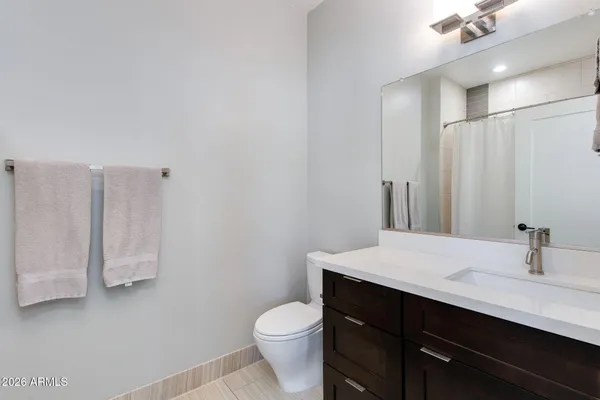 a bathroom with a sink a toilet a mirror and vanity