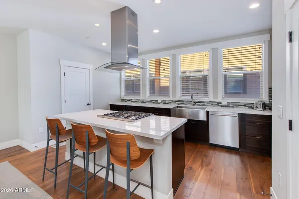 a kitchen with a stove a sink a dining table and chairs