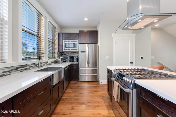 a kitchen with stainless steel appliances granite countertop a sink stove and refrigerator