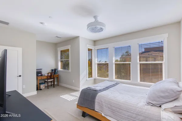 a bedroom with a bed and a large window