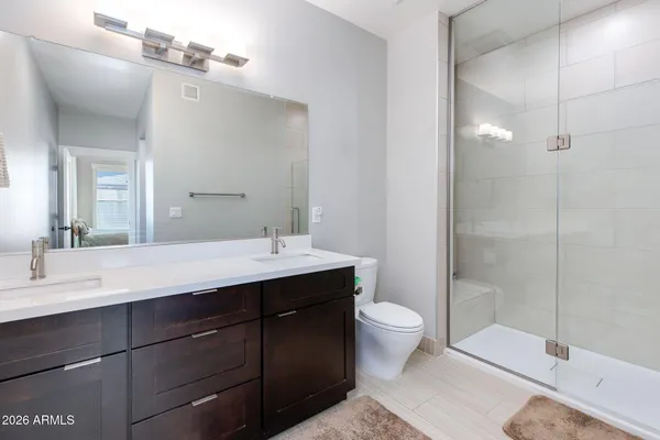 a bathroom with a double vanity sink toilet and shower