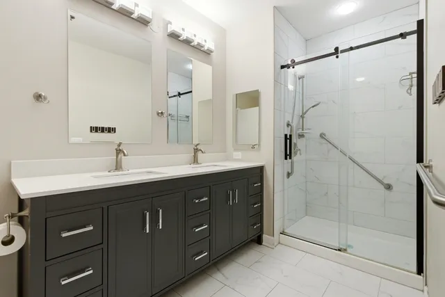 a bathroom with a double vanity sink mirror and shower