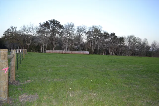 a view of a field with trees in the background