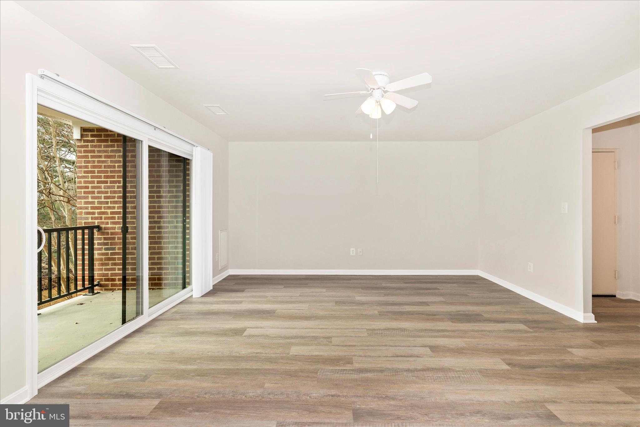 828 Quince Orchard Boulevard, Unit 82820 Gaithersburg, MD 20878 - Photo 12 of 51 a view of an empty room with wooden floor and a window