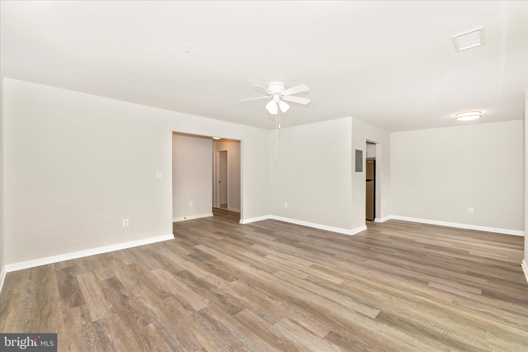 828 Quince Orchard Boulevard, Unit 82820 Gaithersburg, MD 20878 - Photo 15 of 51 an empty room with wooden floor and ceiling fan