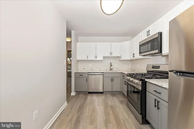 a kitchen with granite countertop white cabinets and white appliances