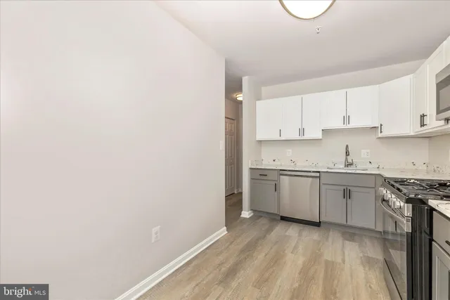 a kitchen with granite countertop white cabinets and white appliances