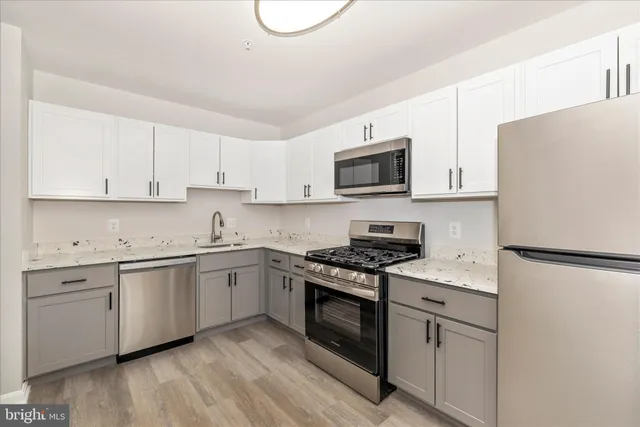 a kitchen with a stove a refrigerator and a microwave