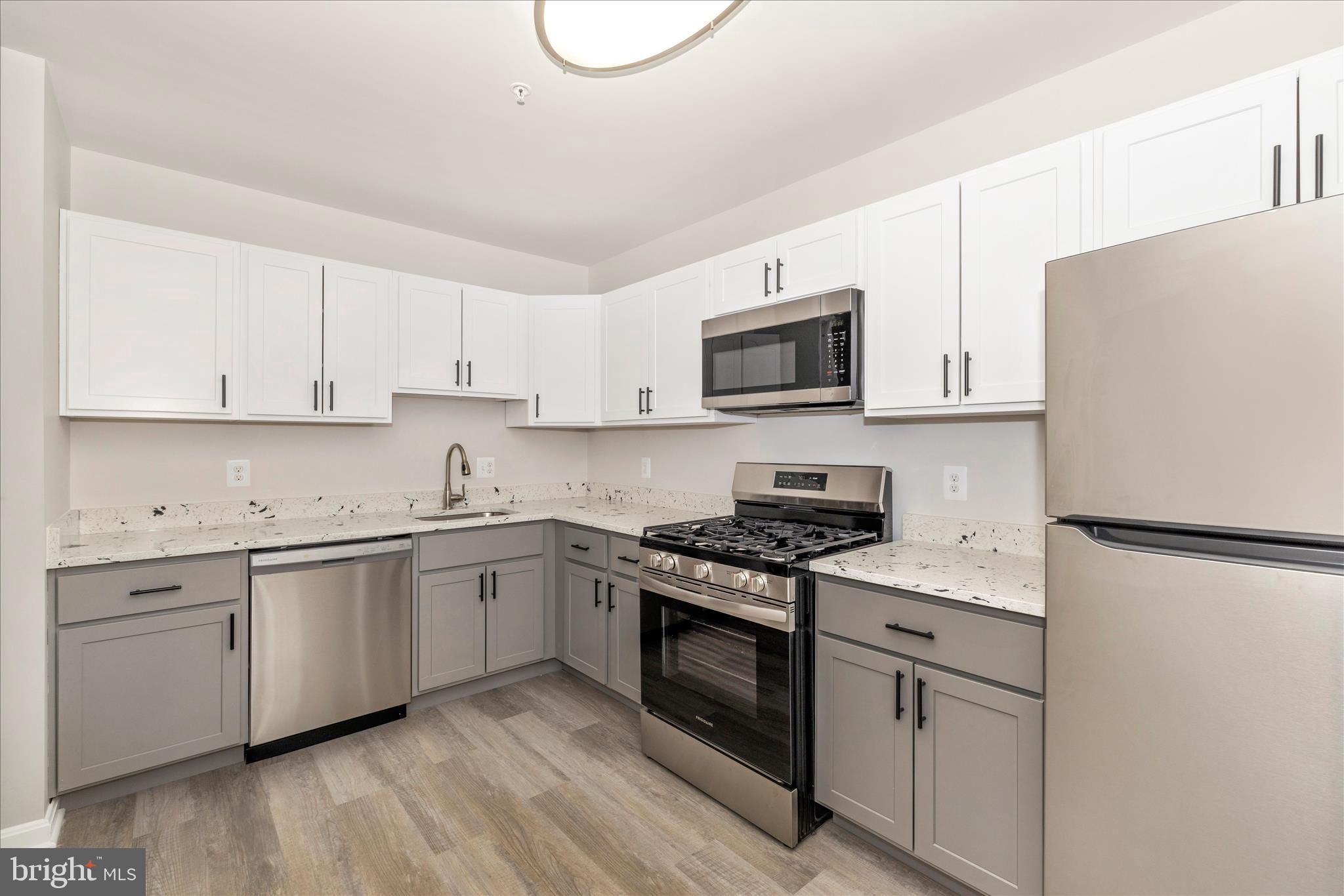 828 Quince Orchard Boulevard, Unit 82820 Gaithersburg, MD 20878 - Photo 28 of 51 a kitchen with granite countertop white cabinets and white appliances