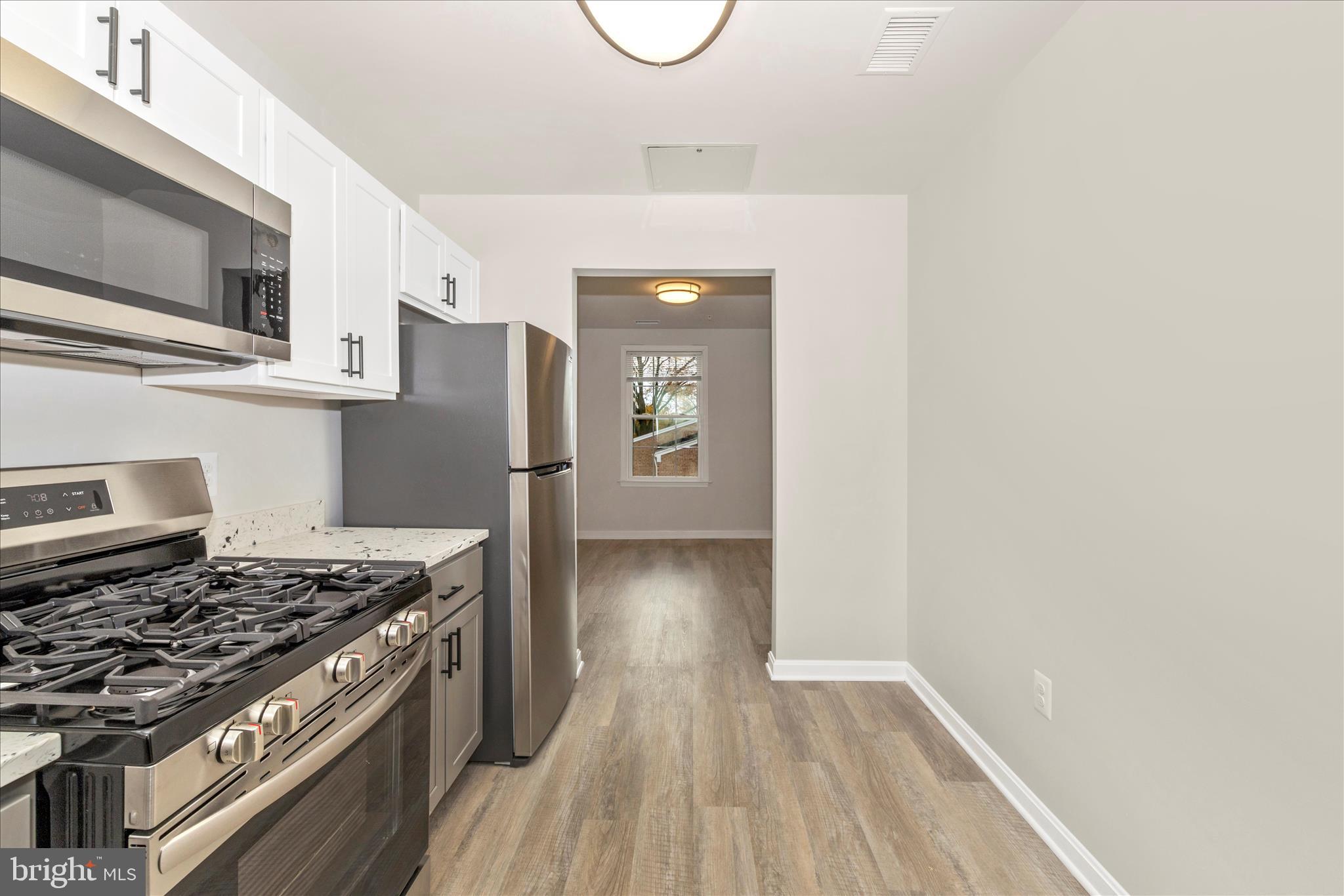 828 Quince Orchard Boulevard, Unit 82820 Gaithersburg, MD 20878 - Photo 31 of 51 a kitchen with stainless steel appliances granite countertop a stove and a refrigerator