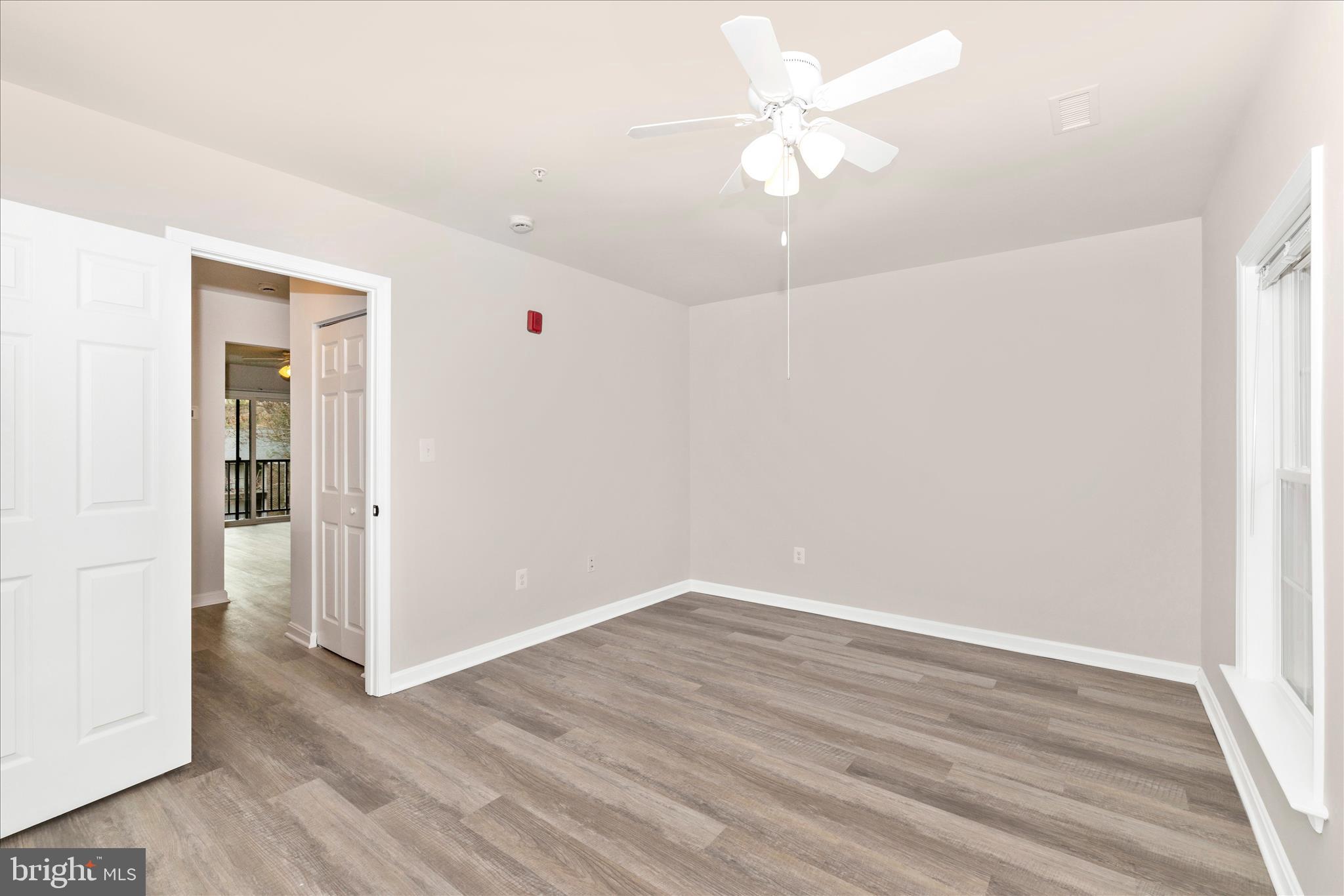 828 Quince Orchard Boulevard, Unit 82820 Gaithersburg, MD 20878 - Photo 35 of 51 an empty room with wooden floor and ceiling fan