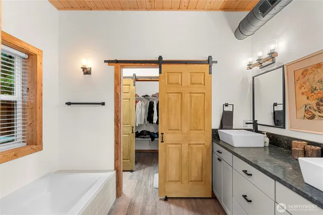 a bathroom with a granite countertop sink a mirror and a bathtub
