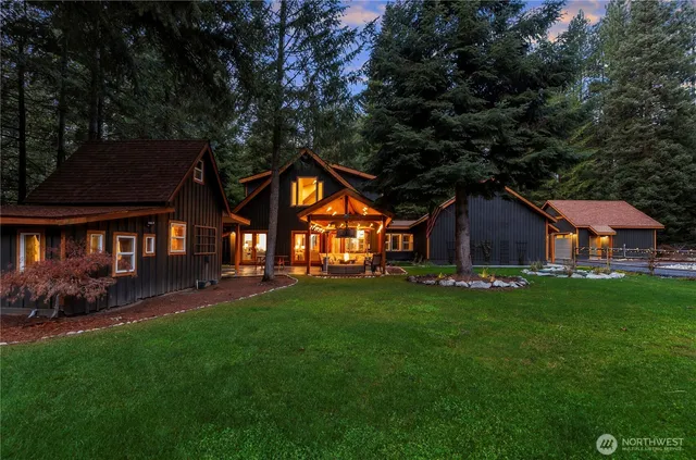 a view of a big house with a big yard and large trees