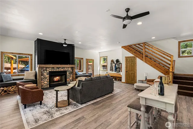 a living room with furniture a fireplace a flat screen tv and kitchen view
