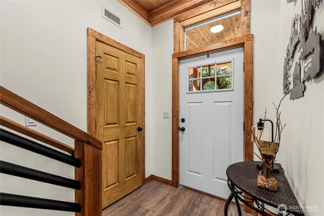 a view of a hallway with wooden floor and furniture