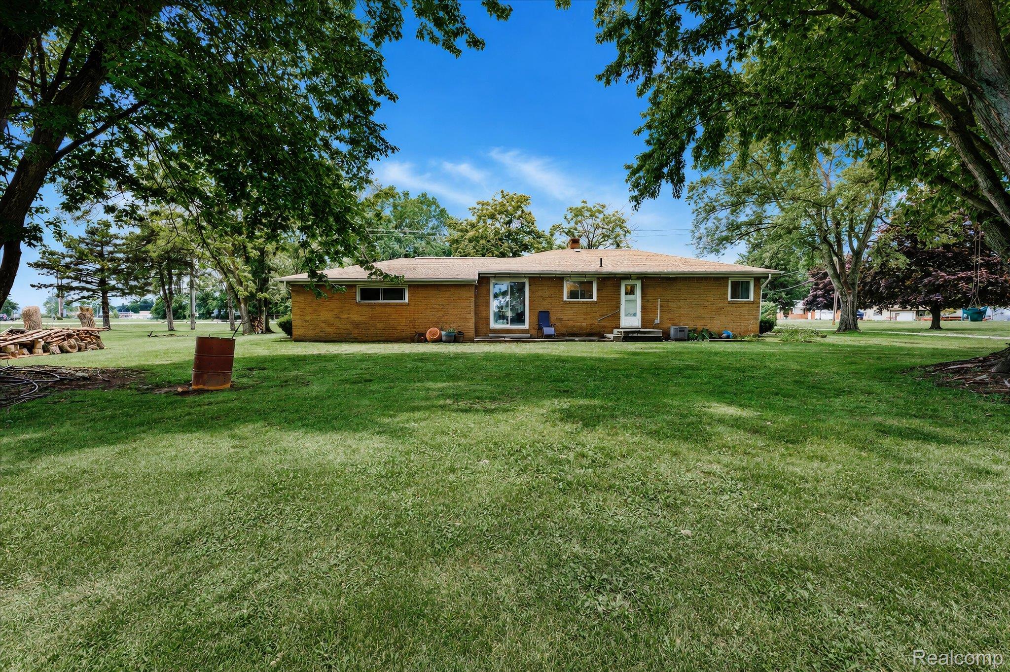 4499 South Linden Road Flint, MI 48507 - Photo 29 of 32 Expansive lawn area with mature trees and a brick exterior