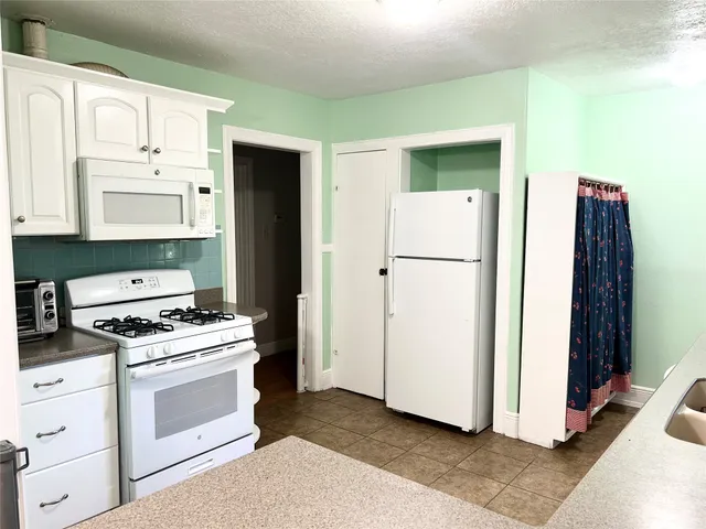 a kitchen with a refrigerator stove and white cabinets