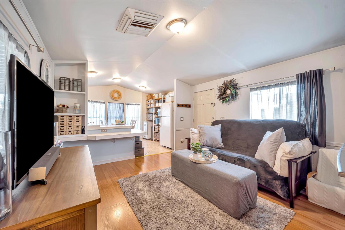 a living room with furniture wooden floor and a flat screen tv