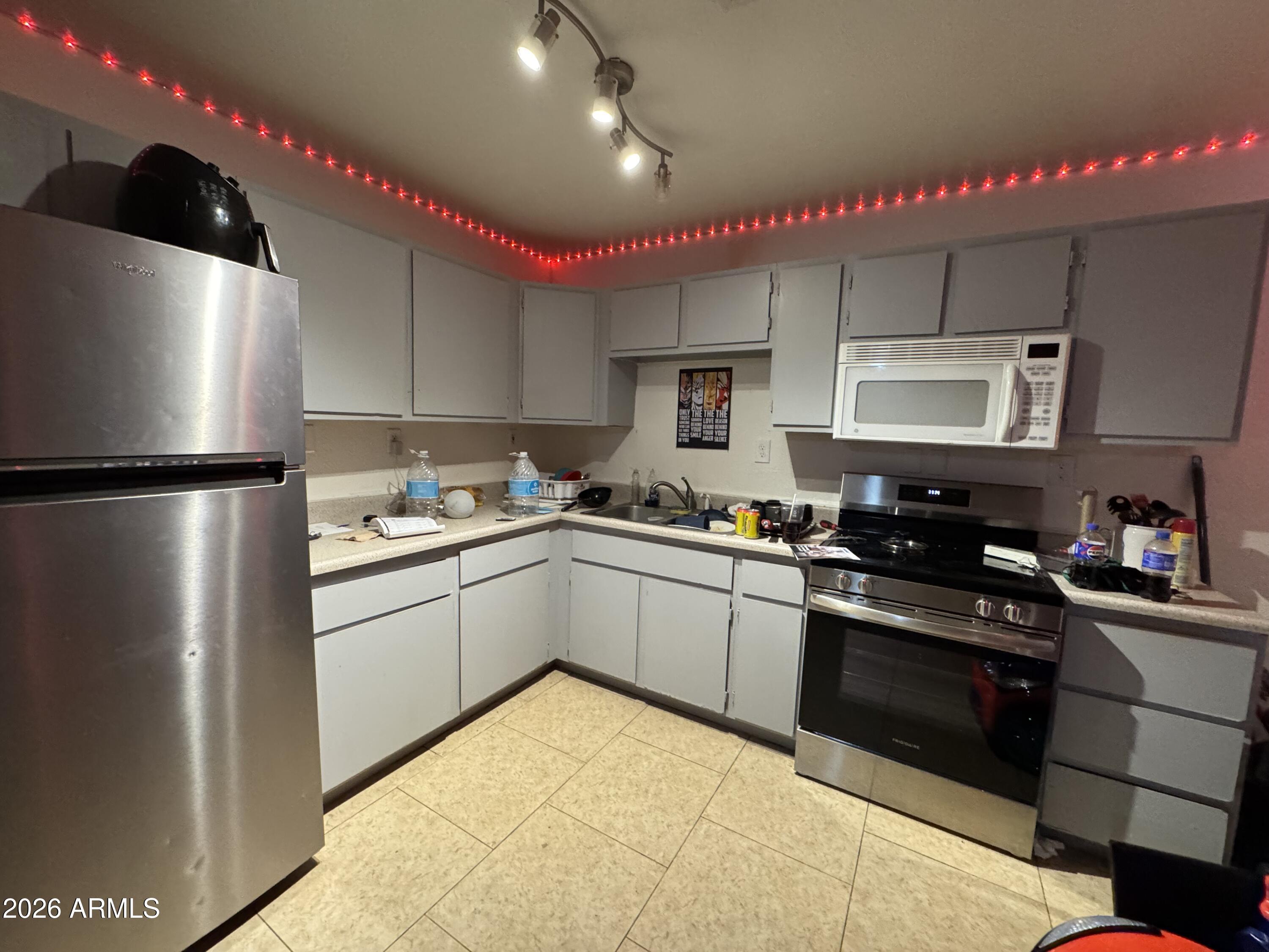 1702 West Shangri-la Road Phoenix, AZ 85029 - Photo 9 of 25 a kitchen with a sink a refrigerator and cabinets