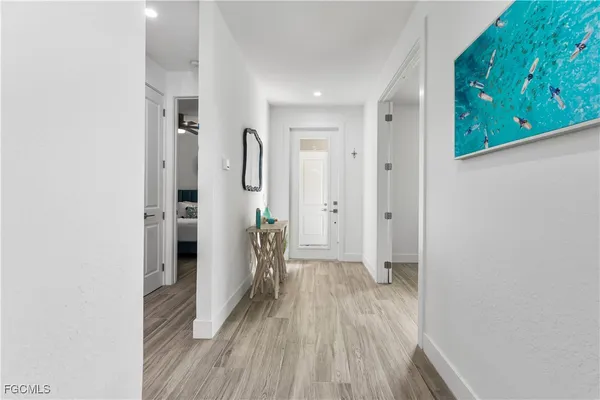 a view of a hallway with wooden floor and staircase